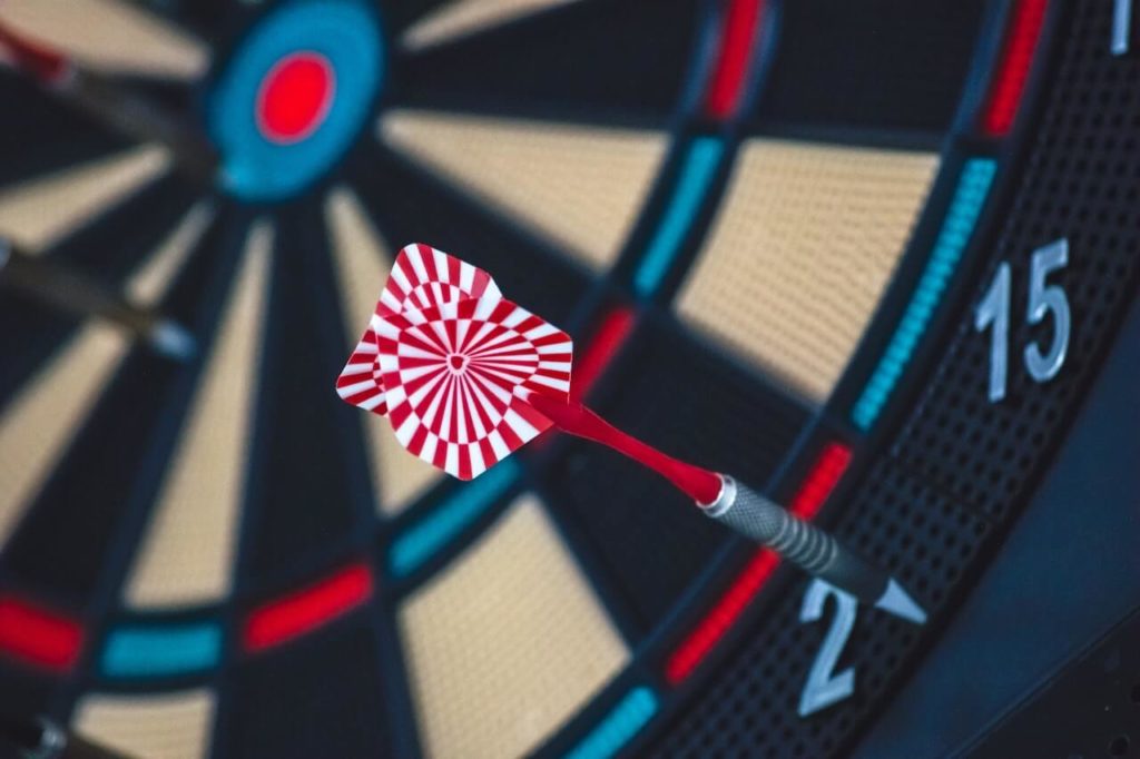 What are process goals: a close up photo of a darts board, the dart has missed all of the numbers on the board.